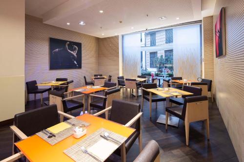 un restaurante con mesas y sillas y una gran ventana en Best Western Plus City Hotel en Génova