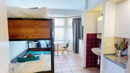a bunk bed in a room with a bathroom at Etagenbett - Küche - Kaffee - Tee - 55" Smart TV in Chur