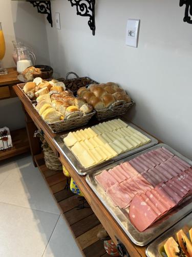 a table with many different types of bread and pastries at Pousada Recanto Da Fé in Aparecida