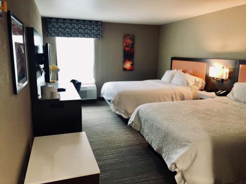 a hotel room with two beds and a television at Hampton Inn El Dorado in El Dorado