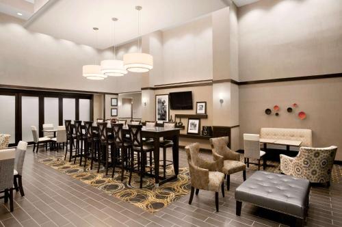 a restaurant with a bar with chairs and tables at Hampton Inn & Suites - Mansfield in Mansfield