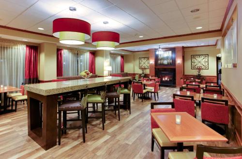 恩波里亞的住宿－恩波里亞漢普頓酒店，餐厅设有酒吧和桌椅