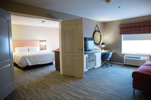 Habitación de hotel con cama y TV en Hampton Inn & Suites Fresno en Fresno