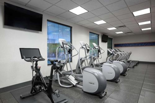 a gym with a row of exercise bikes and a flat screen tv at Hampton Inn Evansville Airport in Evansville