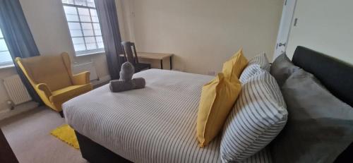 a bedroom with a bed with yellow pillows at The Copper fields in London