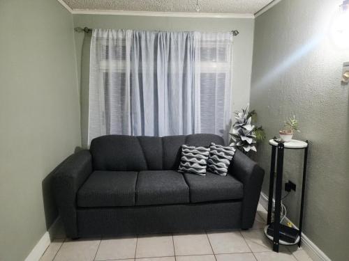 a couch in a living room with a window at JAMI PLACE New Kingston in Kingston