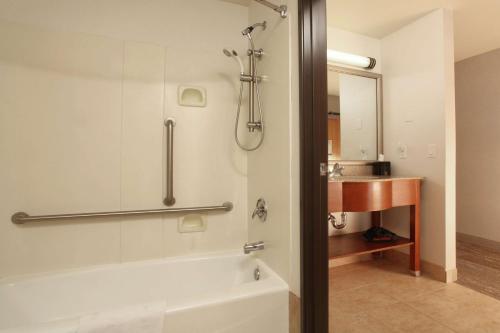 uma casa de banho com uma banheira e um lavatório em Hampton Inn Kalispell em Kalispell