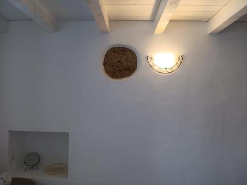 a white wall with a clock and a light on it at Sunny Aljezur da Viana, (Aljezur, Costa Vicentina) in Aljezur