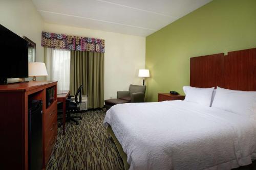 a hotel room with a bed and a television at Hampton Inn Franklin in Franklin
