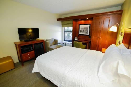 a hotel room with a bed and a flat screen tv at Hampton Inn Franklin, NC in Franklin