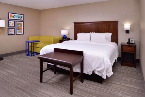 a hotel room with a bed and a yellow chair at Hampton Inn Florence Midtown near University of North Alabama in Florence