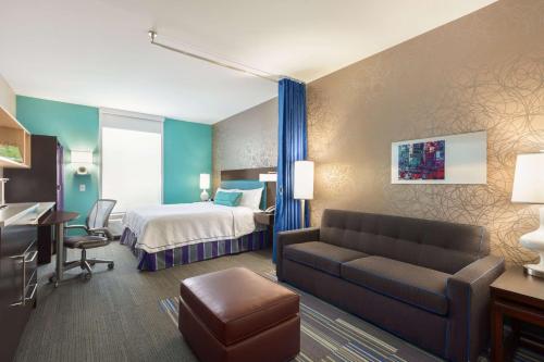 a hotel room with a bed and a couch at Home2Suites by Hilton Florence in Florence