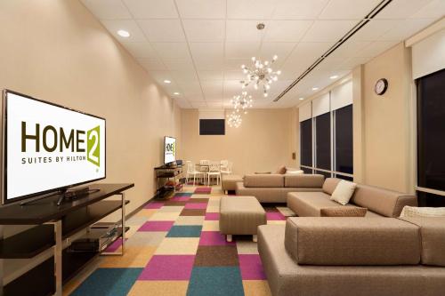 a living room with couches and a flat screen tv at Home2Suites by Hilton Florence in Florence
