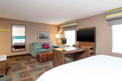 a hotel room with a bed and a television at Hampton Inn & Suites Fort Myers-Colonial Boulevard in Fort Myers