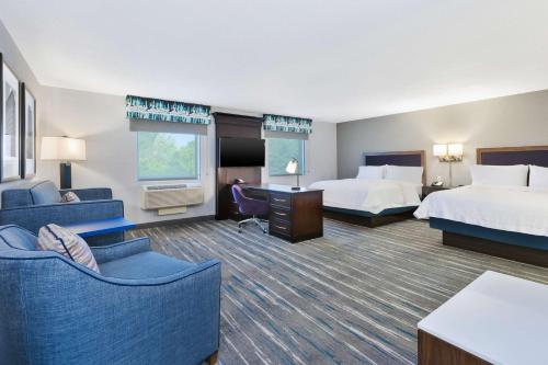 Hampton Inn and Suites Flint/Grand Blanc في فلينت: غرفة فندقية بسريرين واريكة