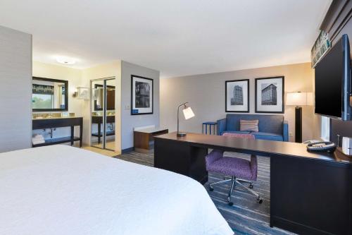 a hotel room with a bed and a desk with a computer at Hampton Inn and Suites Flint/Grand Blanc in Flint