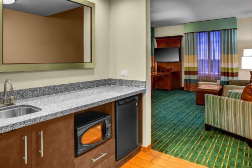 a kitchen with a sink and a living room at Hampton Inn and Suites Coconut Creek in West Dixie Bend