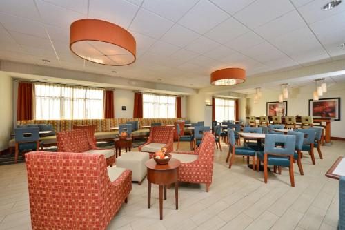 une salle d'attente avec des chaises et des tables ainsi qu'une salle d'attente dans l'établissement Hampton Inn Farmville, à Farmville