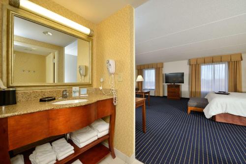 a hotel room with a bed and a bathroom at Hampton Inn Farmville in Farmville