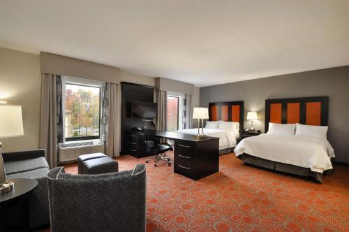 a large hotel room with a bed and a desk at Hampton Inn Stafford / Quantico-Aquia in Stafford