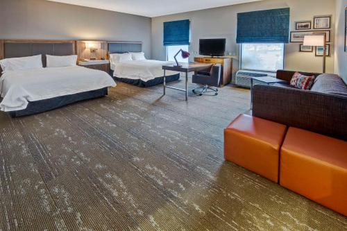 Hampton Inn & Suites Fort Myers Estero في استيرو: غرفة فندقية بسريرين واريكة