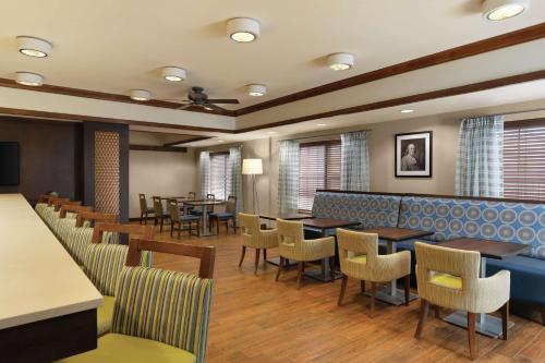 a restaurant with tables and chairs and a bar at Hampton Inn Franklin in Franklin
