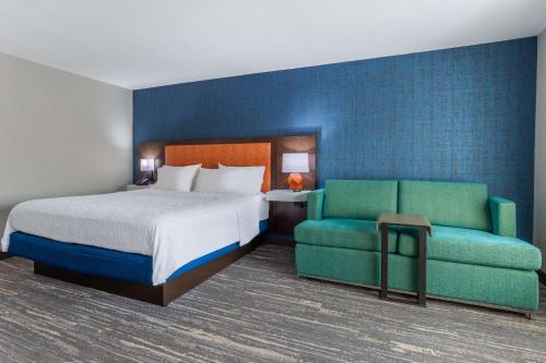 Hayward AdditionにあるHampton Inn Sioux Fallsのベッドとソファ付きのホテルルーム