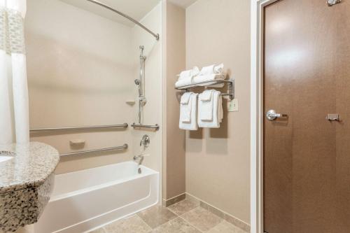 Hampton Inn Auburn في أوبورن: حمام مع حوض استحمام ودش مع مناشف