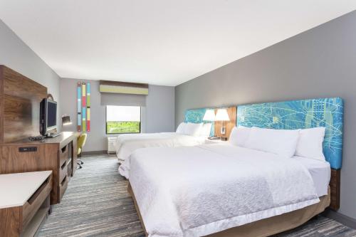 um quarto de hotel com duas camas e uma televisão de ecrã plano em Hampton Inn Auburn em Auburn