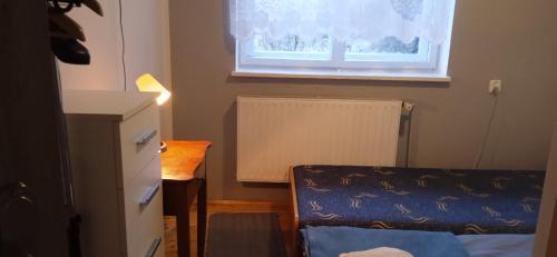 a small room with a bed and a window at Agroturystyka U Baltazara in Duszniki Zdrój
