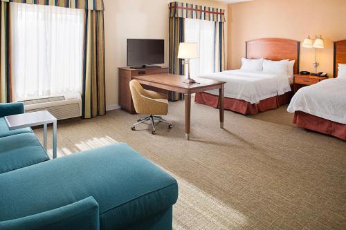 Pokój hotelowy z łóżkiem, biurkiem i kanapą w obiekcie Hampton Inn & Suites - Mansfield w mieście Mansfield