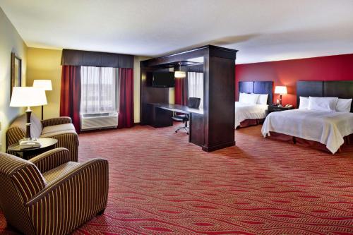ein Hotelzimmer mit 2 Betten und einem Schreibtisch in der Unterkunft Hampton Inn Ft Wayne in Fort Wayne