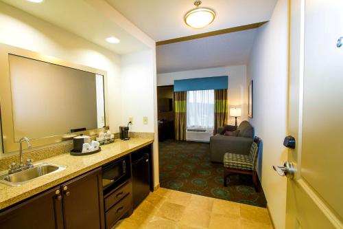 Habitación de hotel con lavabo y sala de estar. en Hampton Inn Fayetteville, en Fayetteville