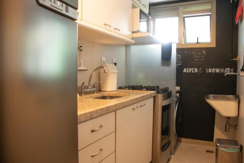 a small kitchen with a sink and a stove at Flat - Leblon in Rio de Janeiro