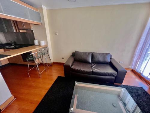 サンティアゴにあるDepartamento con ubicacion perfecta en las condesのリビングルーム(革張りのソファ付)、キッチン