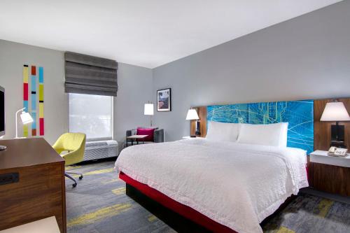 a hotel room with a bed and a desk at Hampton Inn Fayetteville in Fayetteville