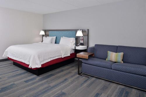 Habitación de hotel con cama y sofá en Hampton Inn - Greenville, en Greenville