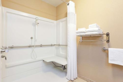 a bathroom with a shower and a toilet and towels at Hampton Inn & Suites Grove City in Grove City