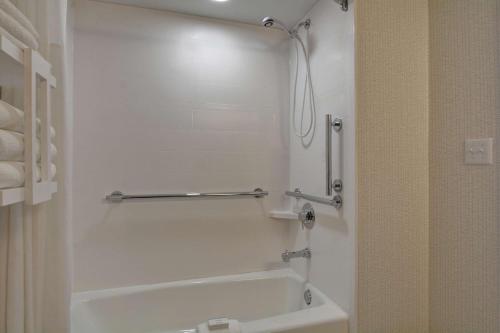 a bathroom with a white tub and a sink at Hampton Inn Greenwood in Greenwood
