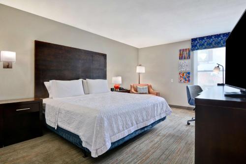 Habitación de hotel con cama y TV en Hampton Inn Greenwood, en Greenwood