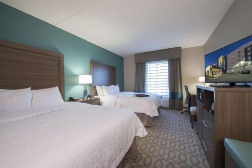 ein Hotelzimmer mit 2 Betten und einem Flachbild-TV in der Unterkunft Hampton Inn Greenville/I-385 Haywood Mall, SC in Greenville