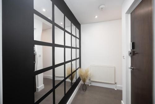 um corredor com uma porta a preto e branco e um vaso em Luxury 2 Bedroom Apartment next to Angel em Londres