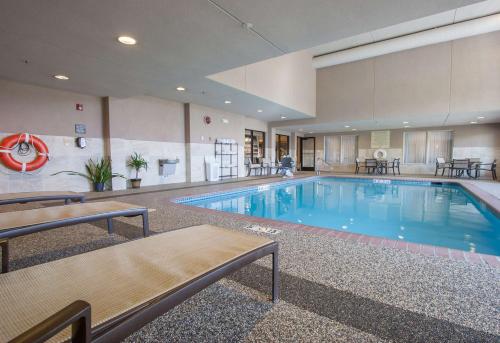 een groot zwembad in een hotel met tafels en stoelen bij Hampton Inn - Great Falls in Great Falls