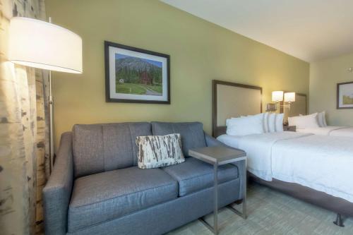 a living room with a couch and a bed at Hampton Inn - Great Falls in Great Falls