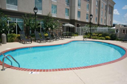 a large swimming pool with chairs and a building at Hampton Inn Guntersville in Guntersville