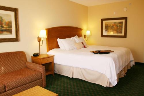 ガンターズヴィルにあるHampton Inn Guntersvilleのベッドと椅子のあるホテルの部屋