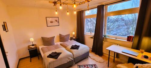 a bedroom with a bed and a desk and a window at Nigella Apartment direkt am Hauptbahnhof Celle für 6 Personen mit kostenfreiem Parkplatz Voll ausgestatteter Küche Elite Standard in Celle