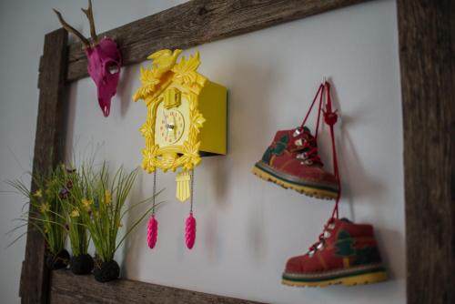 a wall with two shoes and a clock on it at Pension Haus Sanz in Vienna