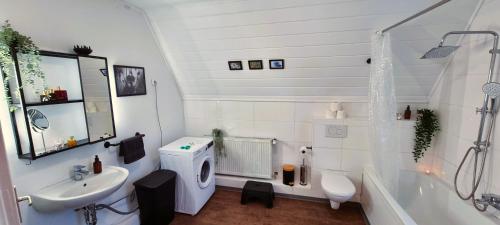 a bathroom with a sink and a toilet and a tub at Nigella Apartment direkt am Hauptbahnhof Celle für 6 Personen mit kostenfreiem Parkplatz Voll ausgestatteter Küche Elite Standard in Celle