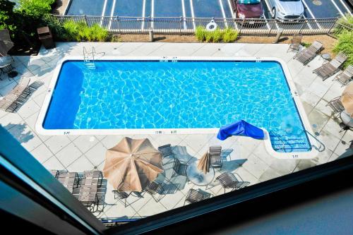 a swimming pool with chairs and umbrellas at Hampton Inn Harrisburg-East/Hershey in Harrisburg